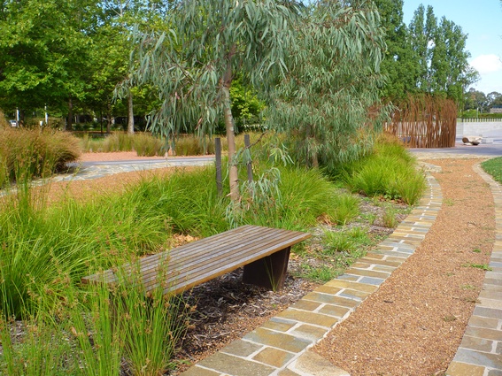 Native planting, organic forms and rustic materials combine to create a deliberate contrast with the highly organised and polished landscape of civic Canberra. The design approaches meet at Reconciliation Place.