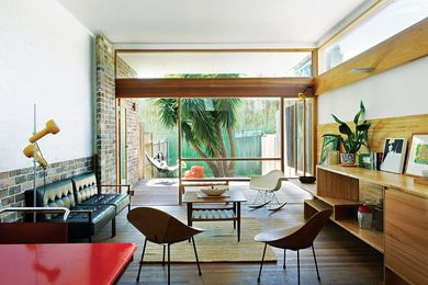 The living areas of this duplex are connected to the outdoors via an elevation of glass with delicate timber frames.