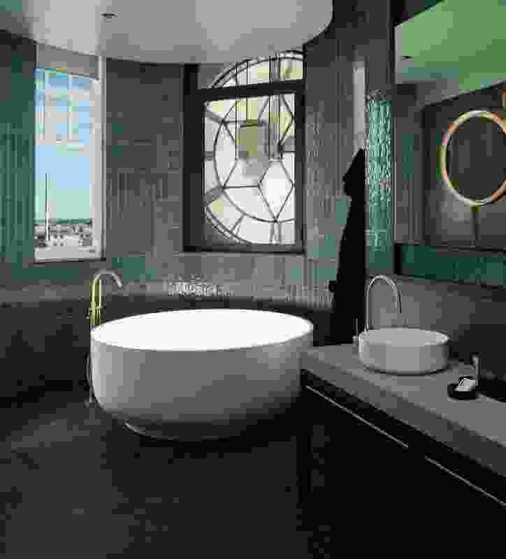 The Clock Suite bathroom is fitted with a lavishly oversized bathtub, surrounded by emerald green finery.