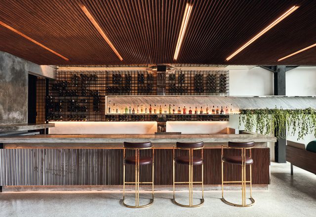In the open-air cocktail bar, timber screens the overhead soffit and bar front, while marble counter- tops and brass-lined stools speak of influences from New York and Miami.