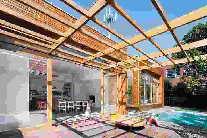 The pool deck sits under a timber pergola that resembles a deconstructed version of the timber-clad pavilion.
