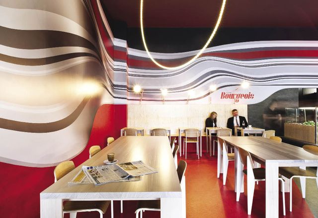 A rippling custom wallpaper design wraps around the interior of Cafe Bourgeois.