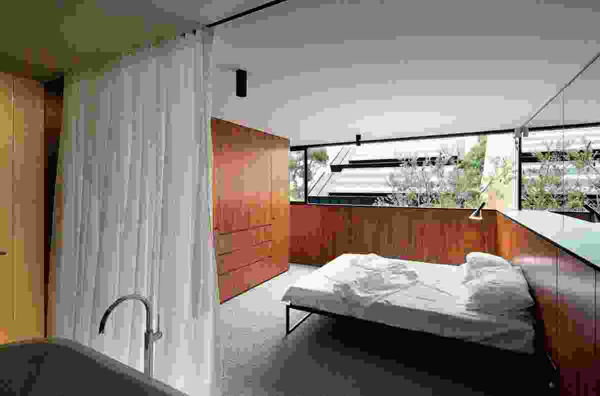 The timber-lined master bedroom with low walls angled out to "scoop in the sun."
