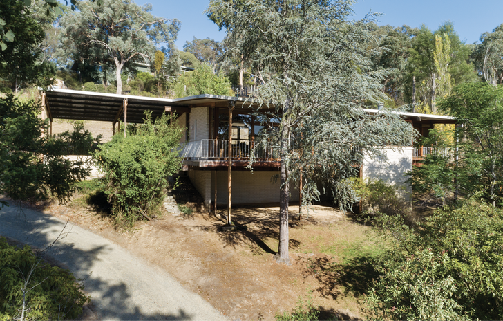 Porter House sits long and low across a sloping one-acre riverfront block with “sweeping views over tree-covered ranges.”