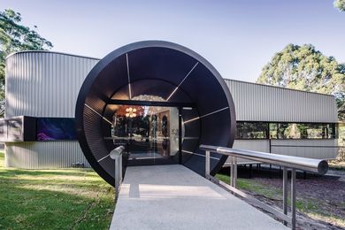 Matt black powdercoating on the projecting entry cylinders – the building’s most monumental aspects – helps them disappear from specific angles.