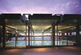 The slab roof and transparent walls of the new pool building.
