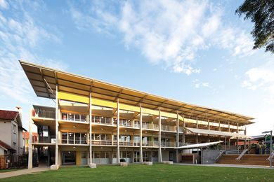 The building’s permeable facade opens onto a central green playground.