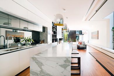 A light court beside the kitchen draws in light, while glazing and mirrors extend the sense of space.