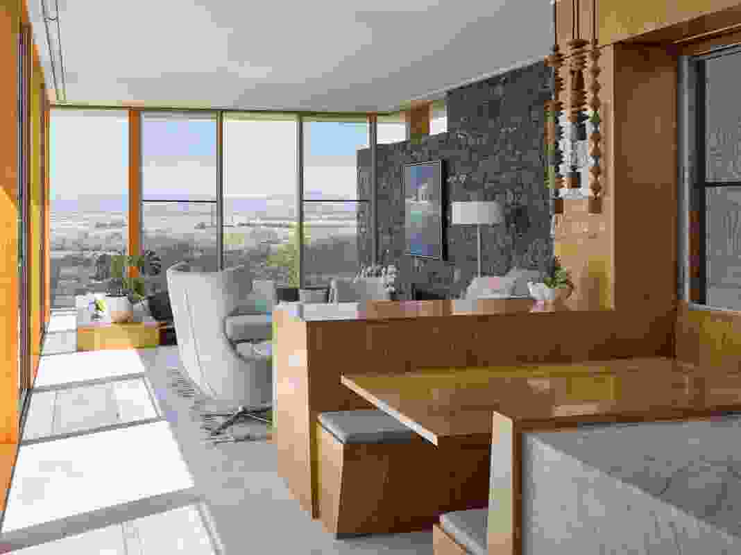 A dining nook and sunken lounge area within the southern wing reach out to distant views. Artwork: Mel Brigg.