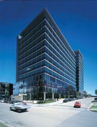 View of the
entry corner. The two rectangular glass towers with
integrated sunshades have been designed to reinforce
the street alignments, while the screen generates a
street scale.