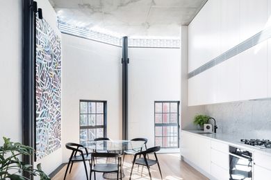 The black and white palette is tempered in the kitchen by a marble splashback and spotted gum timber floors.