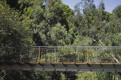 The bridge is positioned midway down the embankment, forming a closeness to the water.