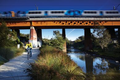 The rail bridge runs above the Merri Creek and the cycling path.