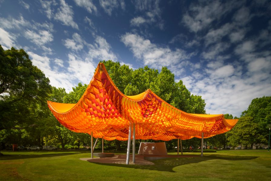 The design of the 2022 MPavilion is a three-layered canopy offering sun and rain protection, with an ever-changing interior atmosphere.