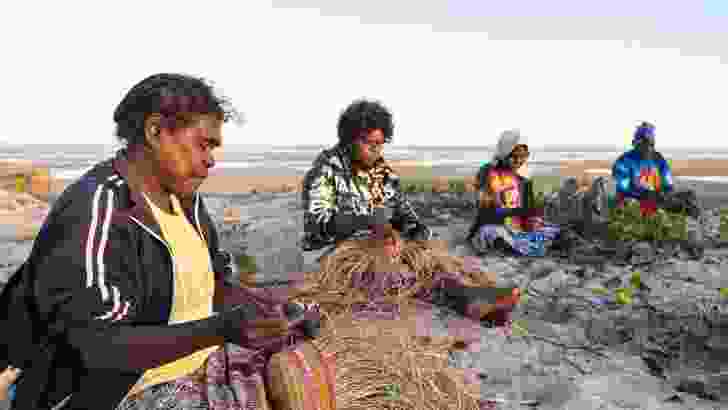 Artists weaving on the beach at Numbulwar.