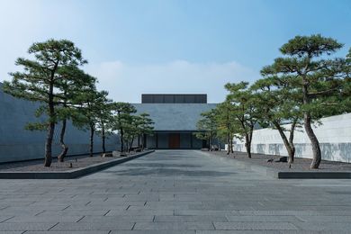 The ensemble forming the resort’s main entrance – a door set in a severe stone-clad box, approached along a tree-lined axis – has a temple-like quality.