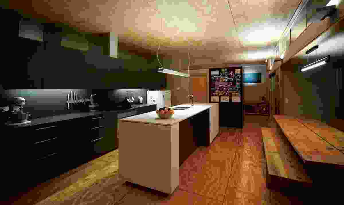 The houses share a similar material palette. Plywood panels on both the ceiling and floor give warmth to the kitchen.