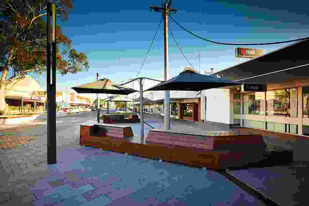 Street furniture crafted from red gum complements the diversity of seating options and directs pedestrian flow along the north-south axis of the street.