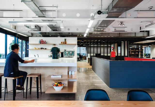 The office’s kitchen features a monolithic kitchen bench, with views to Sydney harbour.