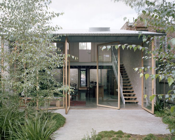 Tall pivoting glass doors open the home to the garden.