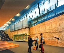 Lower level of the foyer, with the rock wall excavated during construction. Image: John Gollings