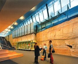 Lower level of the foyer, with the rock wall excavated during construction. Image: John Gollings