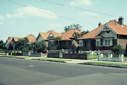 Federation saw freestanding homes, supposedly individual but really just a flipped repeat of the next-door-but-one. Queen Anne details are rendered in “Aussie” motifs but the verandahs face the street, not the sun. The same size house now takes more space. Image: Tone Wheeler