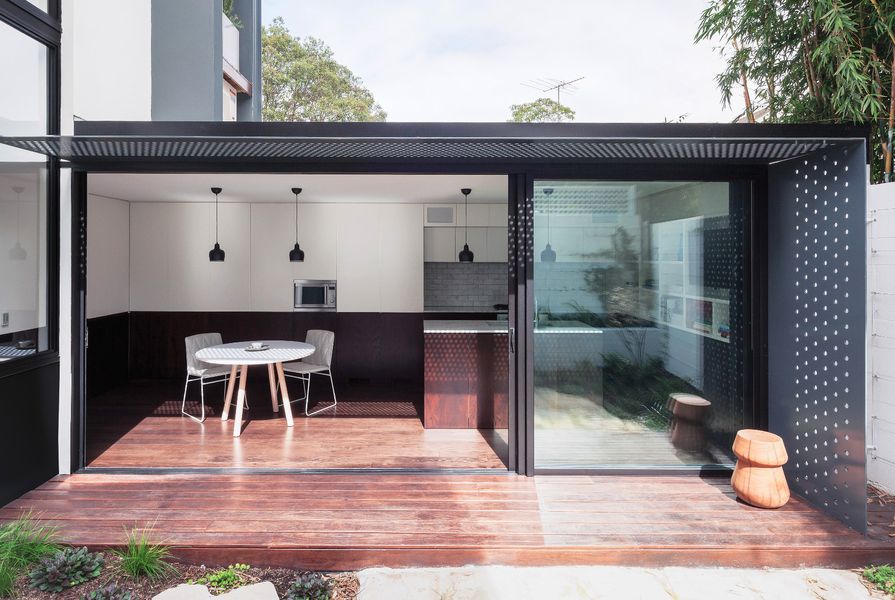 The new low-slung kitchen/dining pavilion is orientated north to face a lush garden of granite slabs and herbs.