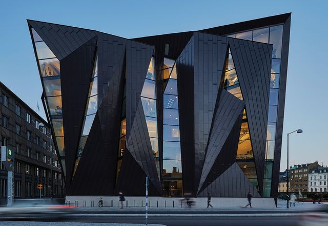 The extension wraps and folds around the existing building, its form referencing the junction of the orthogonal city grid and rotated axis of the harbour.