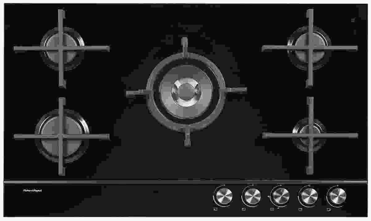 Gas cooktop on glass with iron trivets. 