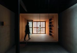 While the darkness of the roof cavity appears to extend space vertically, the living room at the back of the house creates a sense of depth.