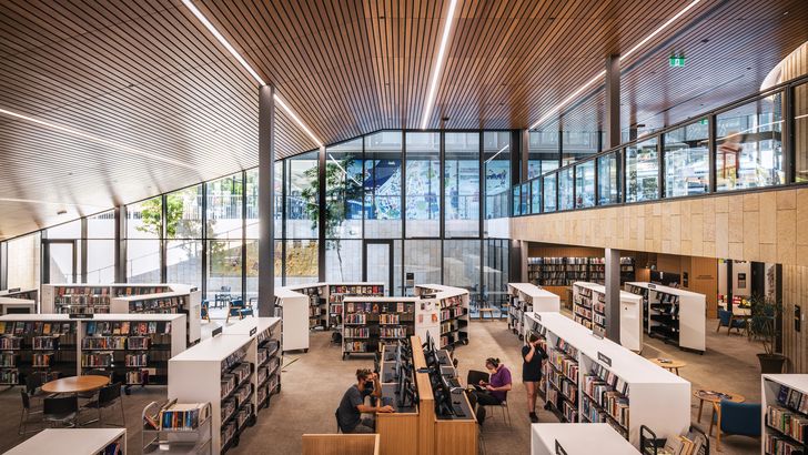 The design makes use of the slope to create a double-height library below grade, while physical transparency ensures that the spaces feel connected.