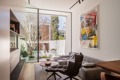 The house opens onto an elegantly designed courtyard with a garage and studio beyond. Artwork: Linus Bill and Adrien Horni.