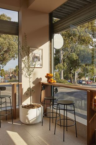 Timber benches offer a place for patrons to perch or dine, overlooking Kew’s leafy surrounds.