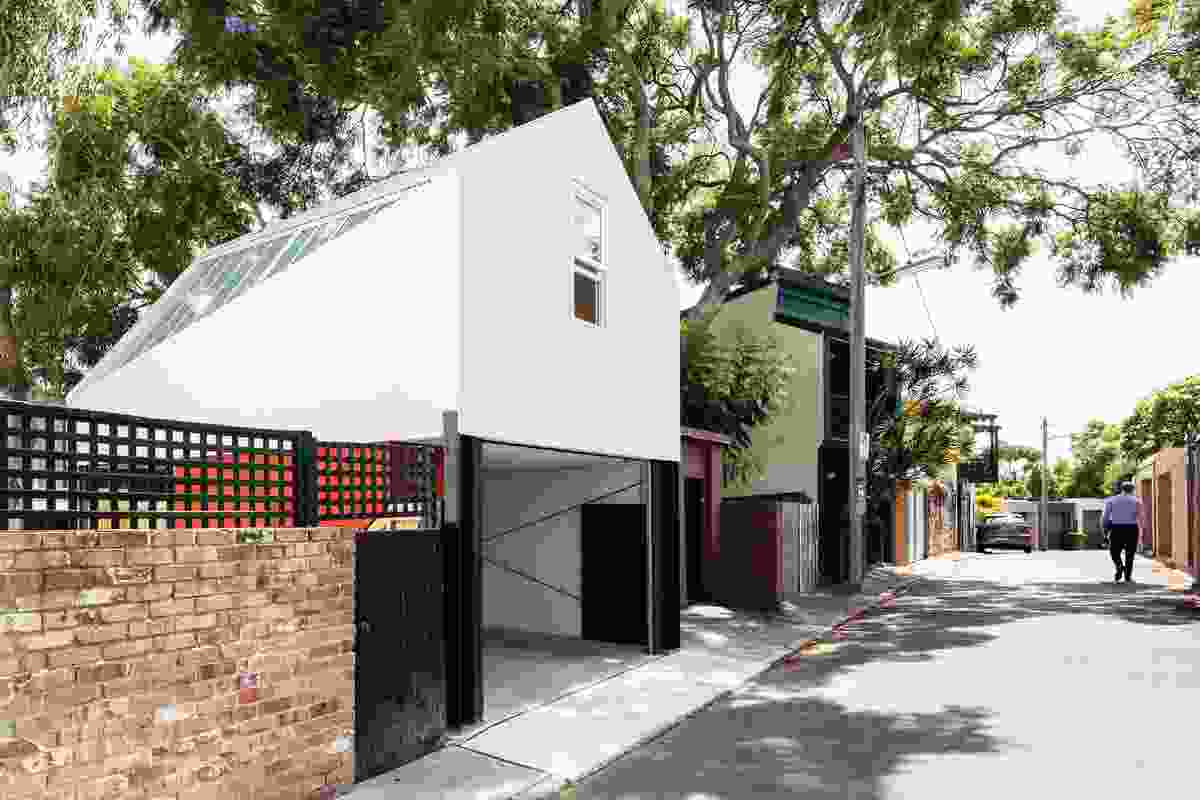 The studio presents a modest facade to the rear lane, but adopts a more playful form to address the existing house.