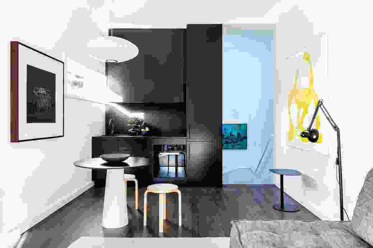The self-contained apartment is served by a small but functional kitchen and living space on the top floor. Artwork: Unknown (left); Henry Mullholland (at stair); Tamara Mendels (right).