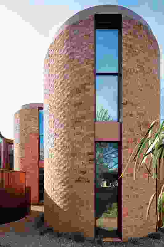 The iconic shape of the rural water tower is incarnated in brick drums that anchor the form of the house.