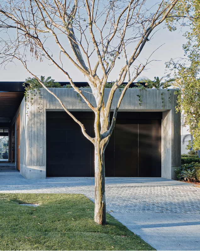 The home’s street-facing elevation hints at the materiality of the interiors.