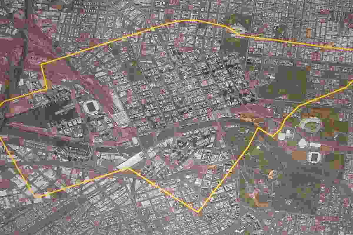 The Hazelwood Open Cut Mine boundary plotted in yellow over an aerial image of central Melbourne at the same scale. 