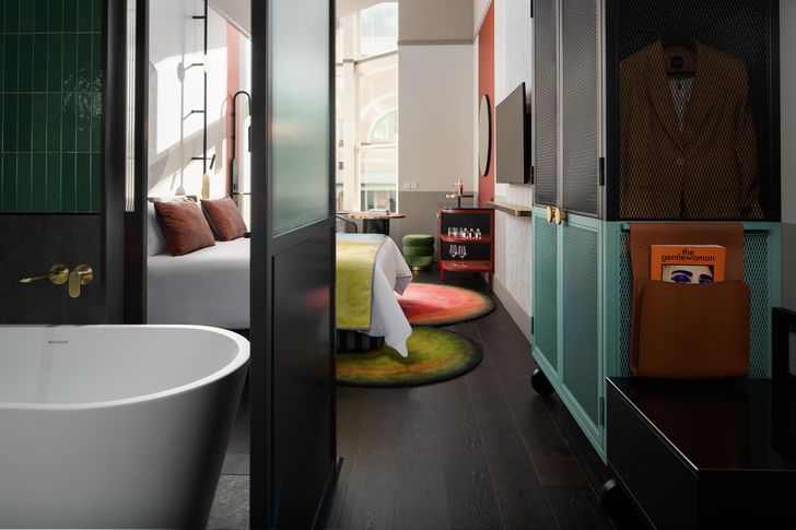 The Clock Suite bathroom is fitted with a lavishly oversized bathtub, surrounded by emerald green finery.