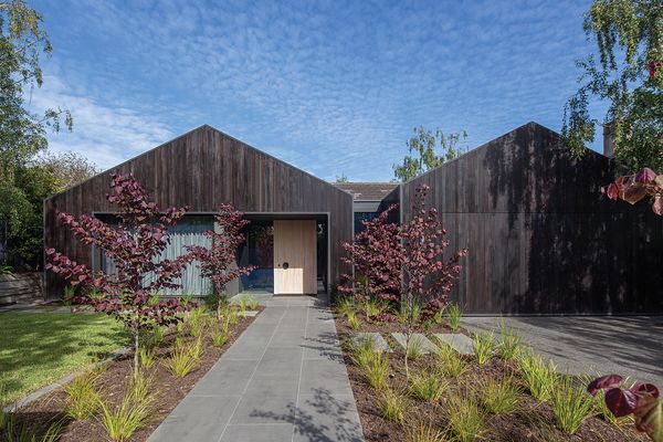 A striking facade of charcoal-stained timber radically alters the house’s appearance in the streetscape.