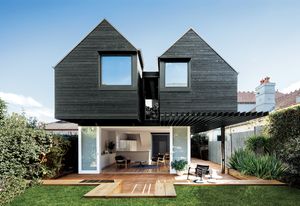 Twin first-floor pavilions and ample openings connect the house to the garden and sky.