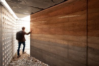 A rammed earth wall in different soil types gives the project a layered, tactile quality. 