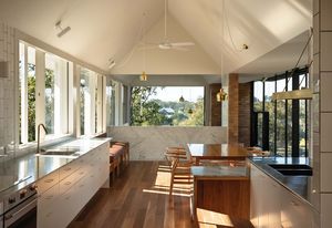 A long gable over the northern wing connects the new living spaces and directs sight lines toward the river.