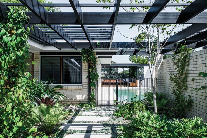 The black aluminium pool fence marks the threshold between two distinctly different spaces – one enclosed and the other open to the sky.