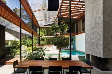 Slender steel columns support exposed ironbark beams that frame the roof and shadecloth canopy.