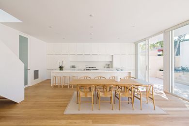 The new living area includes a large kitchen in a crisp, white palette that continues throughout the house.