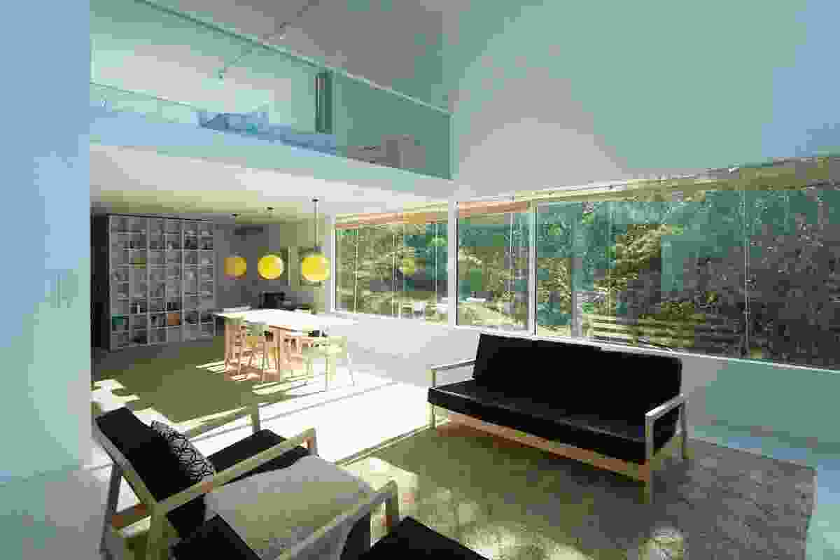 In the lower-level living space, the eye is focused towards the mid-ground detail of the lush, green garden through the northern window.