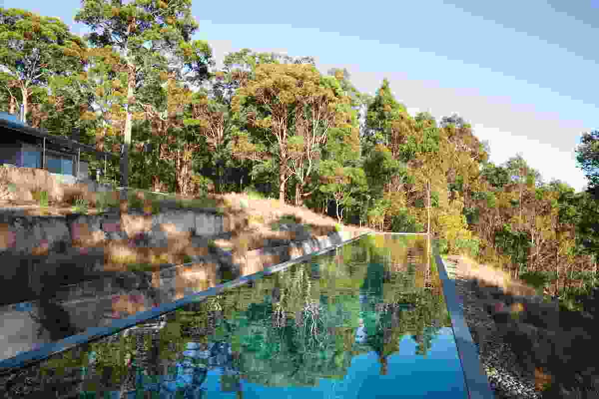 The long rectangular pool sits within a series of terraces marked by sandstone walls.