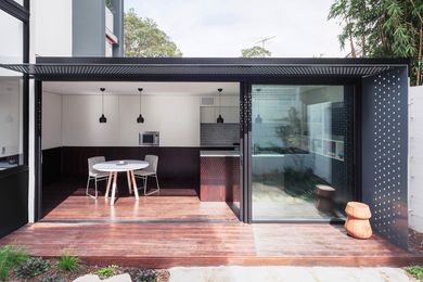 The new low-slung kitchen/dining pavilion is orientated north to face a lush garden of granite slabs and herbs.